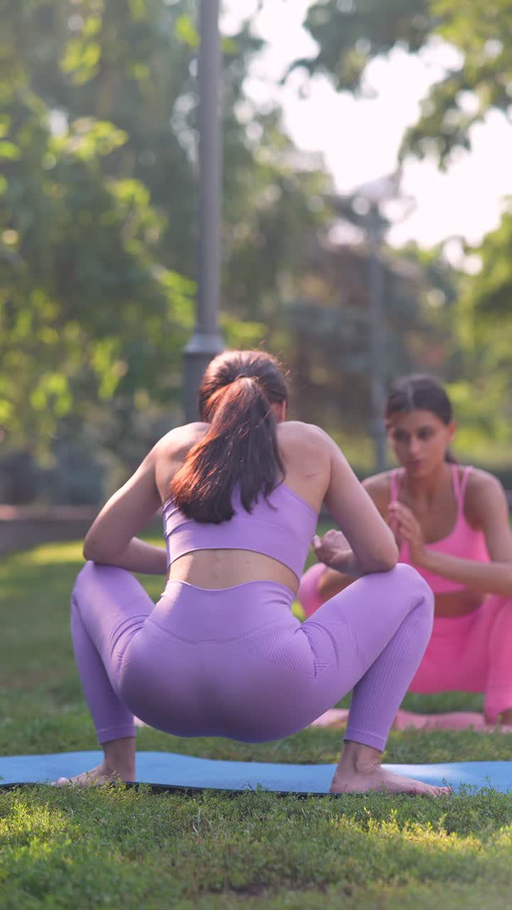 dos mujeres practicando yoga en un parque