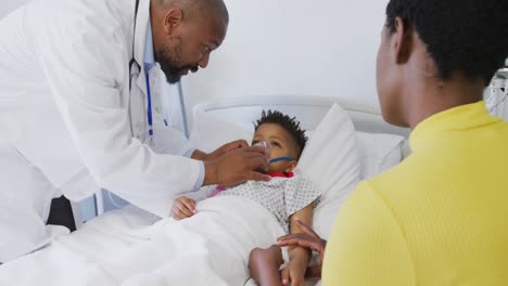 Médico-Varón-Afroamericano-Examinando-A-Un-Paciente-Infantil-En-El-Hospital