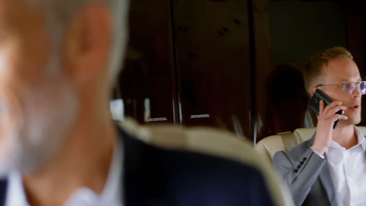 개인 제트 4k로 여행하는 동안 휴대 전화로 이야기하는 사업가