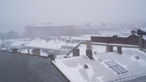 static shot of snow falling over rooftops of buildings at st