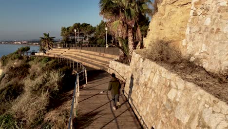 man running on a coastal path in catalonia, spain on a summer day