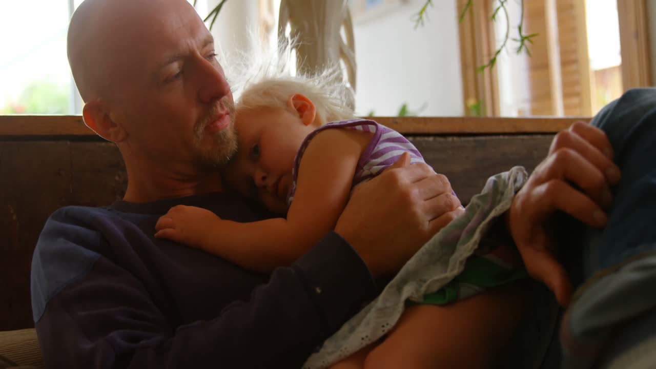 Padre e figlia che si rilassano sul divano 4k