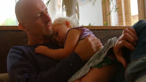 father and daughter relaxing on sofa 4k