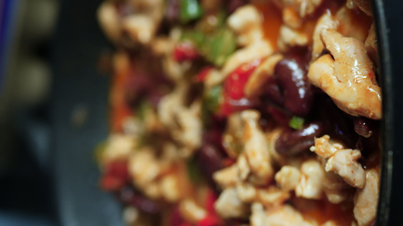 pollo, pimientos, frijoles para las fajitas cocinando en sartén