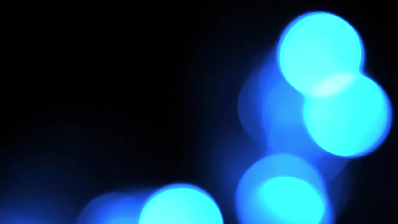 Abstrakte blå bokeh-lys glødende på sort baggrund