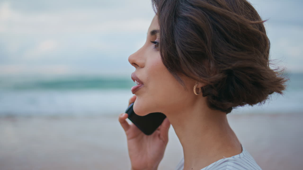 Closeup stylish brunette calling friend at shore. Relaxed girl going ocean beach
