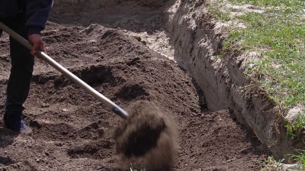 Jardineros cavando una zanja para un jardín de lluvia que almacena agua en suelo seco