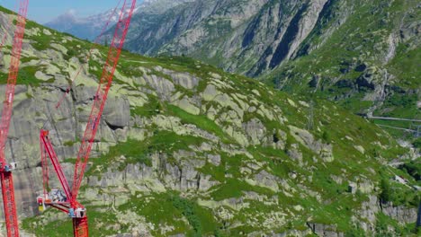 Big-red-cranes-in-the-Swiss-Alps,-on-a-clear-summer-day