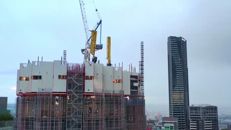 aerial side view of 443 queen street building construction site with tower crane on top, brisbane city australia