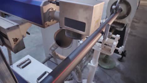 close-up view of industrial machinery working on a metal pipe, highlighting the precise cutting and shaping process in a modern manufacturing facility.