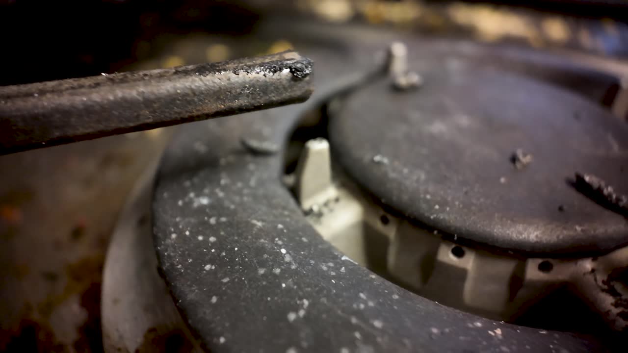 Dirty gas hob burner with grime and food residue needing cleaning