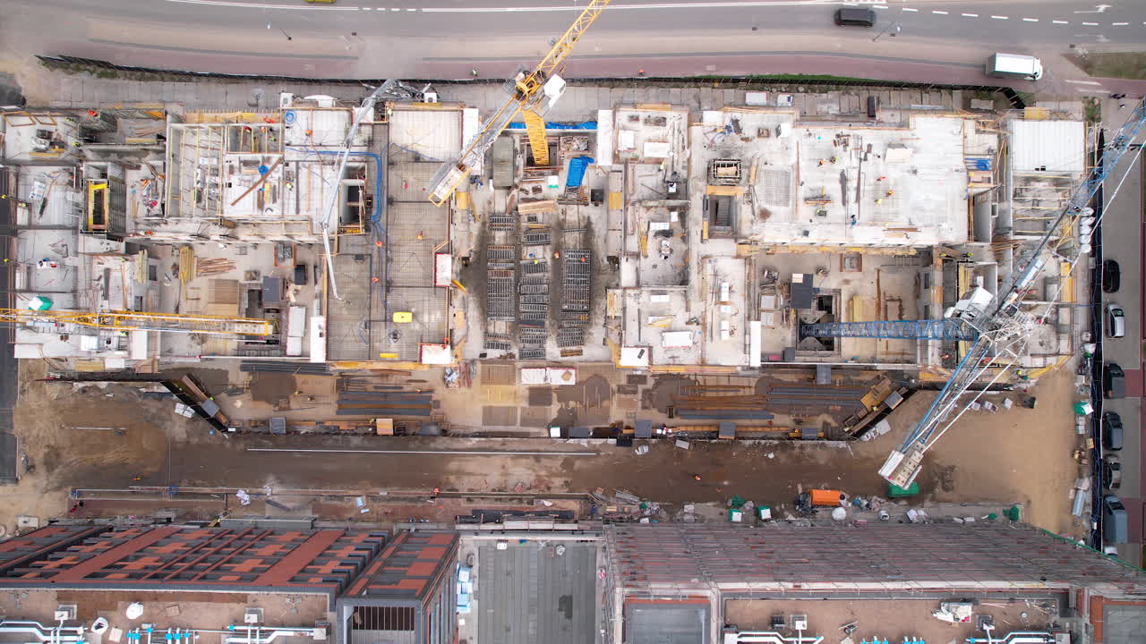 disparo aéreo de arriba hacia abajo de una grúa en el sitio de construcción al lado de la carretera en el centro de la ciudad de gdansk