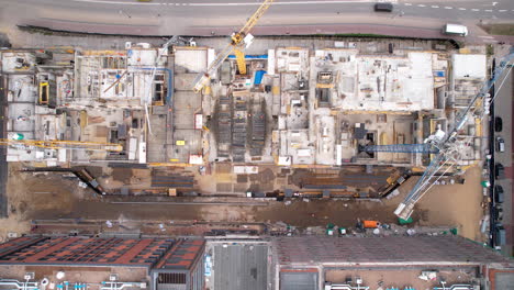 Aerial-top-down-shot-of-crane-at-construction-site-beside-road-in-Center-of-Gdansk-City