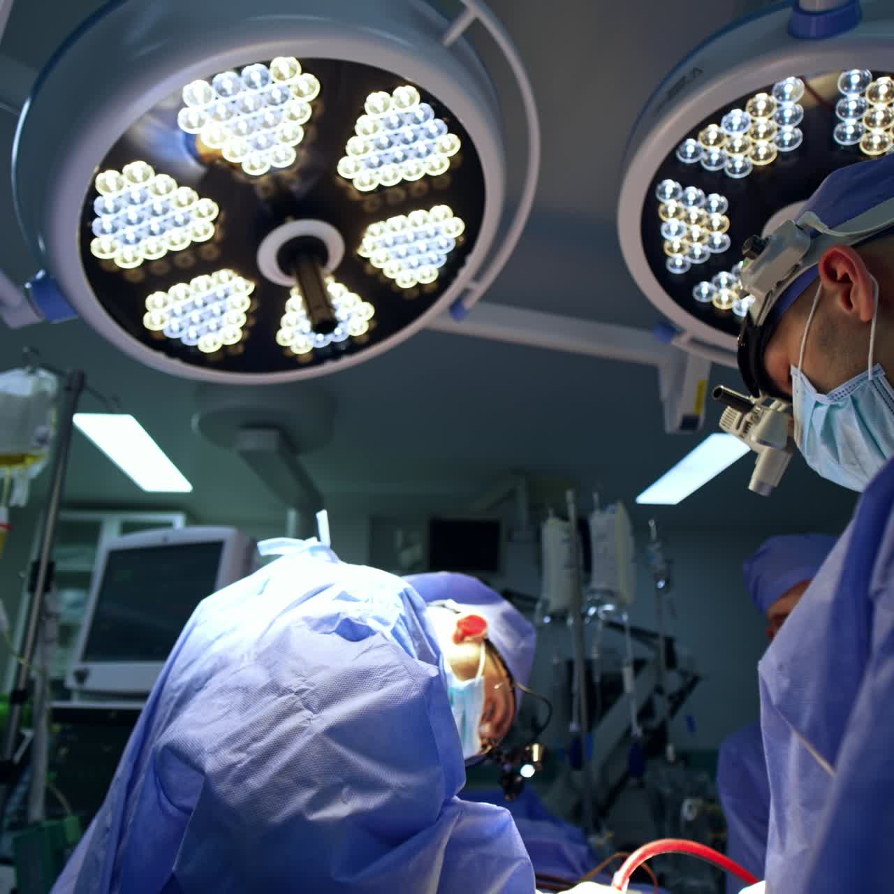 Equipo de neurocirujanos realizando una operación en un quirófano moderno. Los médicos llevan gafas con dispositivo durante la cirugía.