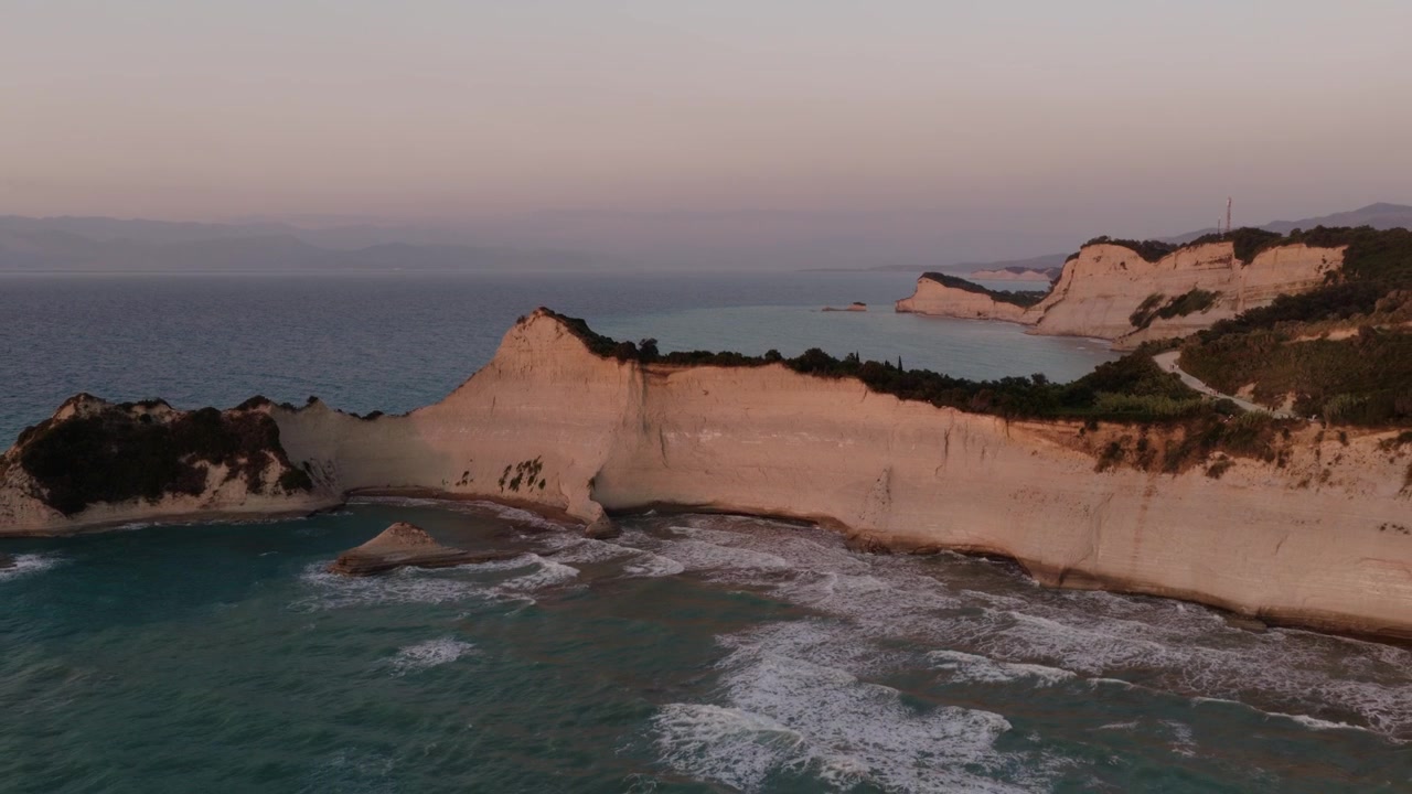 Vista drone delle scogliere calcaree di Capo Drastis che brillano al tramonto, Corfù.