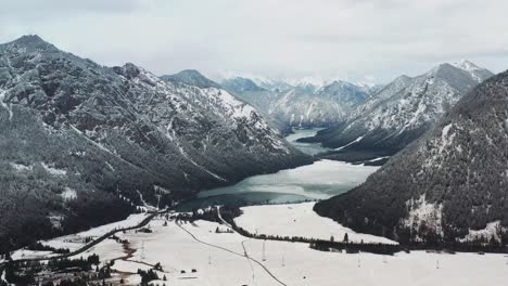 aerial drone view of majestic snow-capped austrian alps, roads and rivers winding through the landscape