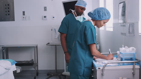 surgical team reviewing patient paperwork in hospital operating theater