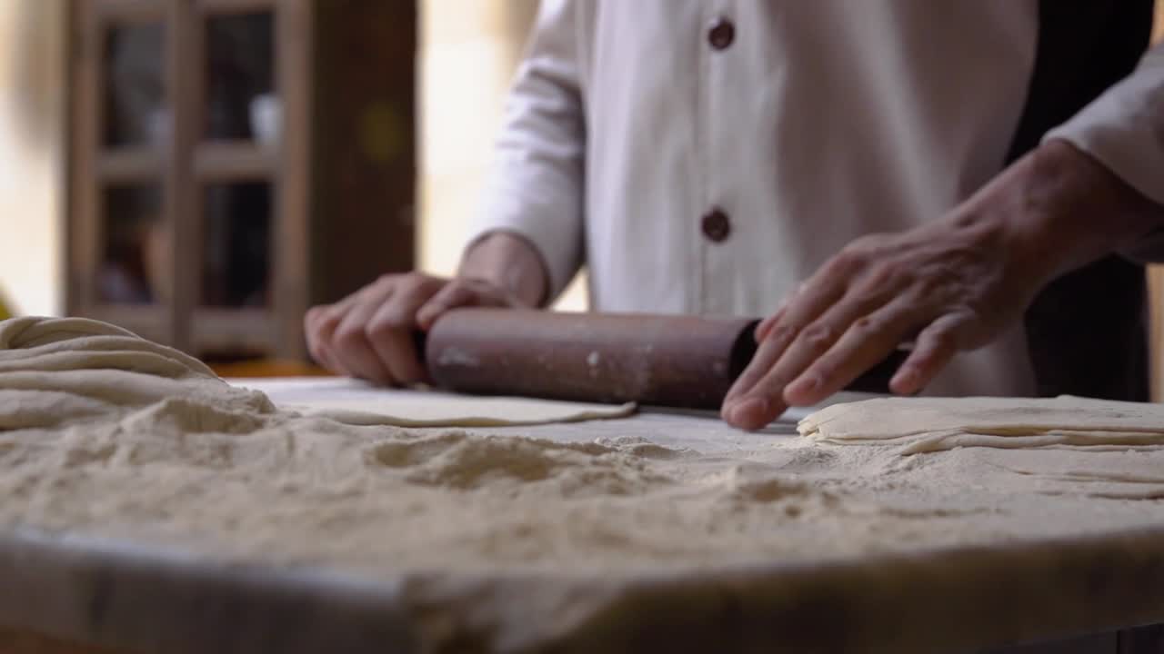 Dough Being Rolled in Slow Motion By Baker in Traditional Bakery
