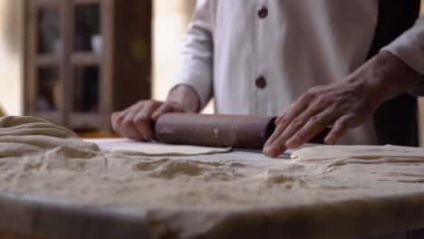 La-Masa-Se-Enrolla-A-Cámara-Lenta-Por-Un-Panadero-En-Una-Panadería-Tradicional