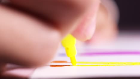 child coloring with yellow marker