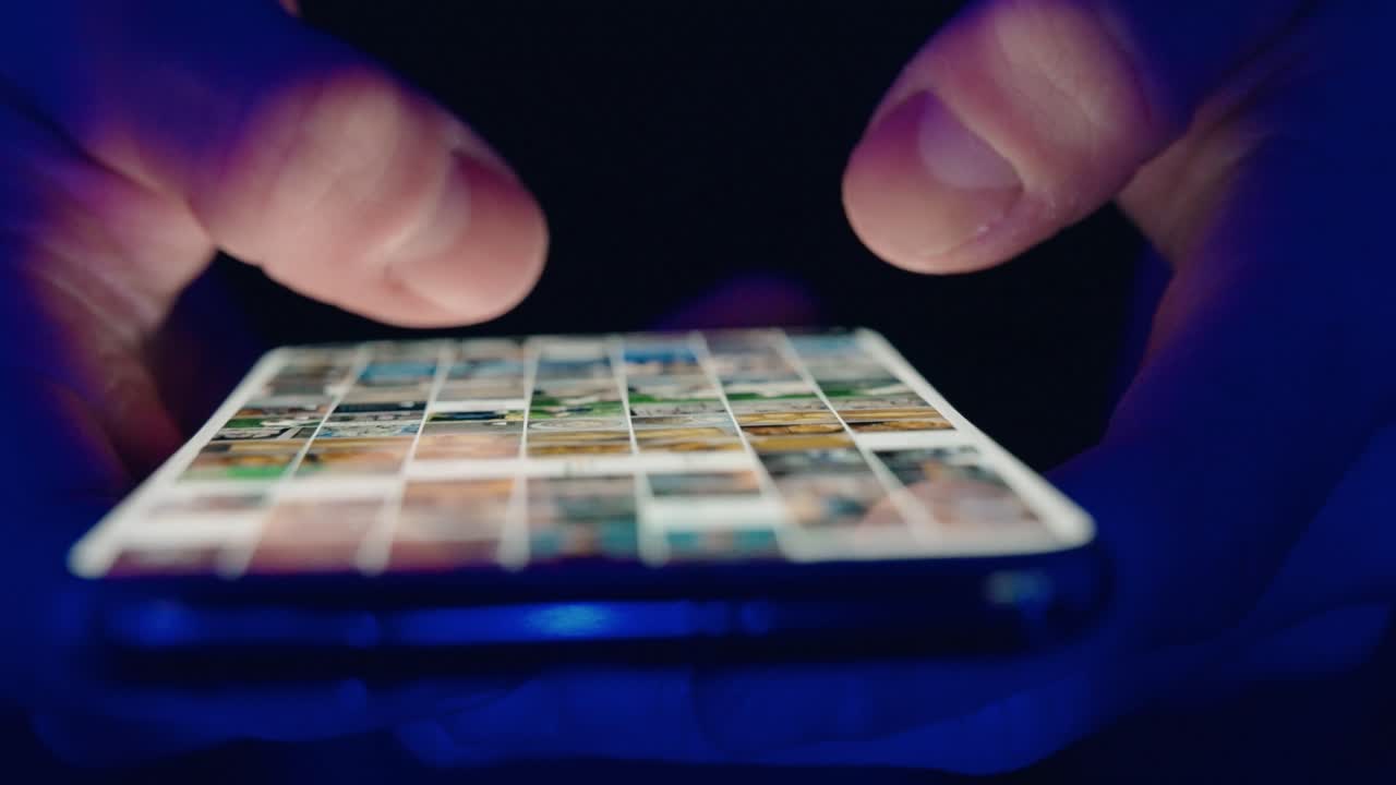 primer plano de las manos de un joven desplazando imágenes de las redes sociales