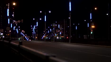 night view of an empty city street with illuminated lamp posts