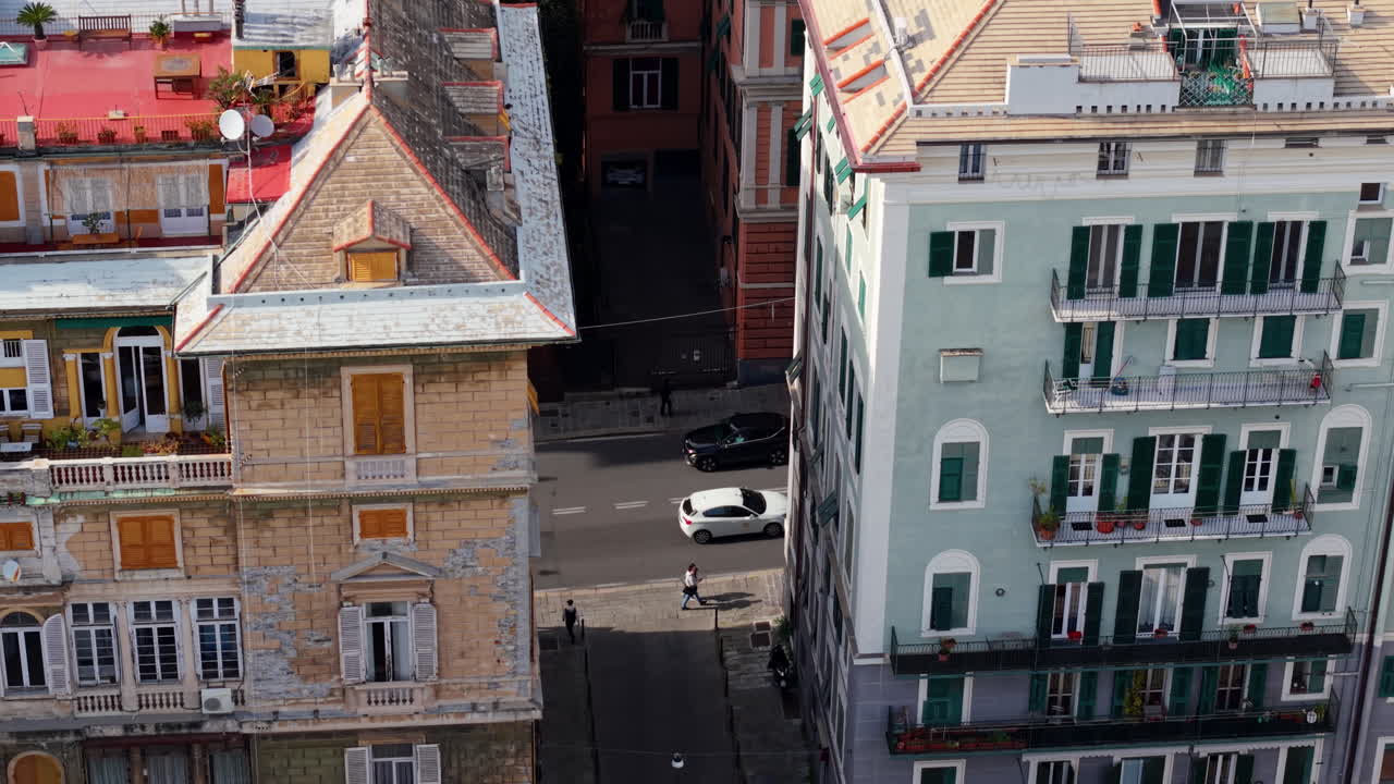 Vista aerea di edifici storici colorati nel soleggiato paesaggio urbano di Genova.