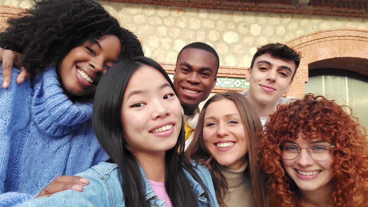 Asian young woman taking a selfie with friends outdoors