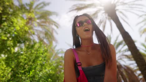 young woman enjoying a sunny day outdoors surrounded by palm trees