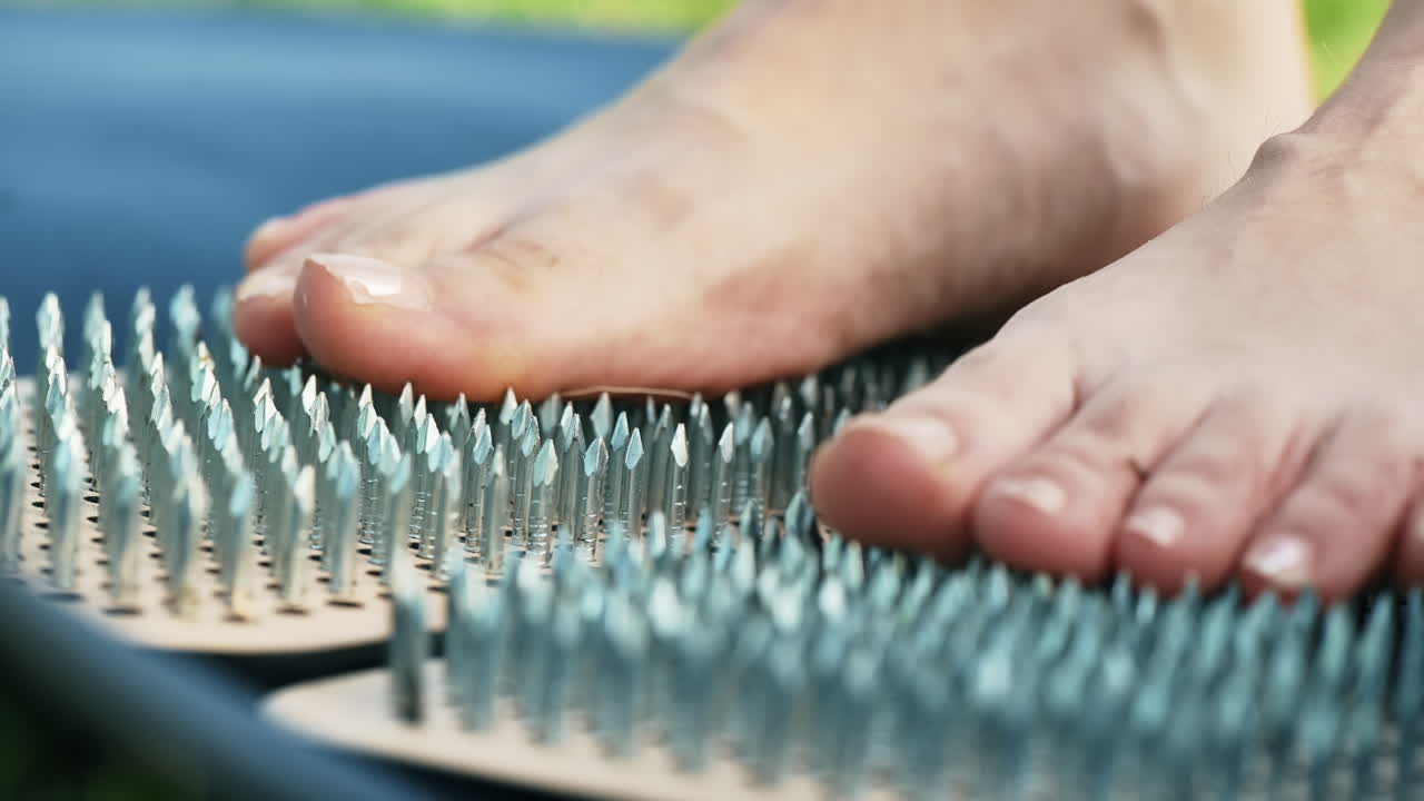Primo piano di una donna in piedi sui chiodi