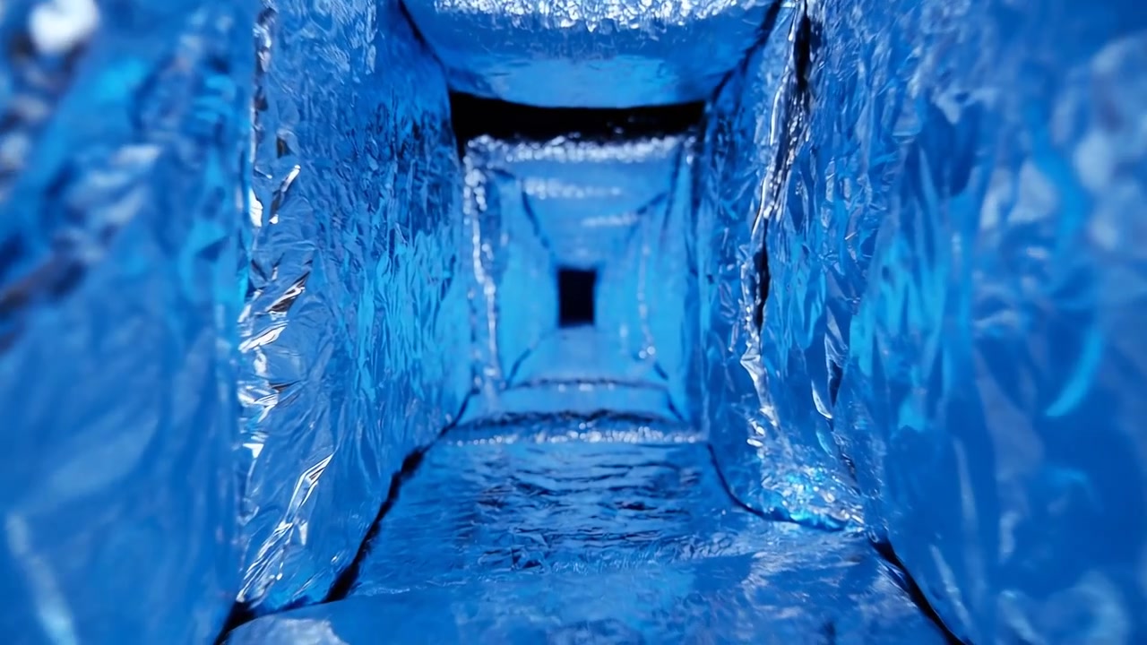 Close-up tunnel interior fully lined with crinkled metallic foil, saturated cool-blue illumination, strong central perspective, reflective texture, narrow rectangular shape, and futuristic abstract