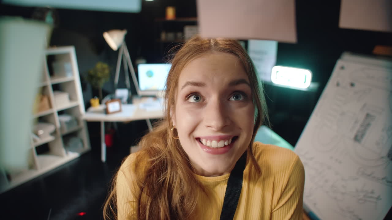 una chica satisfecha en primer plano mirando el tablero de pegatinas en una oficina hipster nocturna.