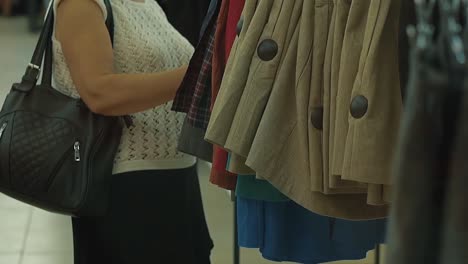 elderly woman chooses her clothes in a supermarket