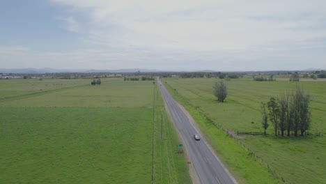 driving on asphalt road through lush green fields in kempsey, new south wales, australia