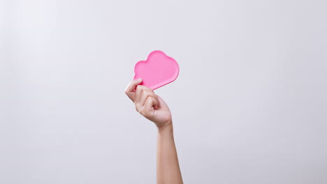 la mano de la mujer muestra un símbolo de color rosa de icono de nube en fondo de estudio blanco con espacio de copia