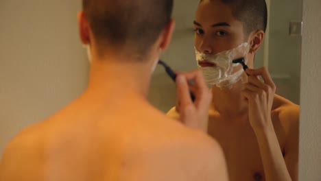 man shaving with razor in bathroom at home 4k