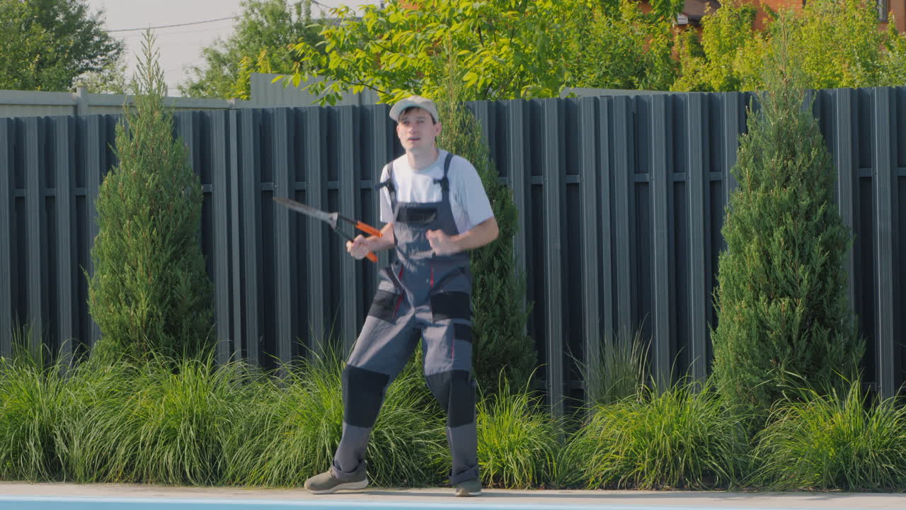 jardinero realizando trabajos de mantenimiento cerca de una piscina