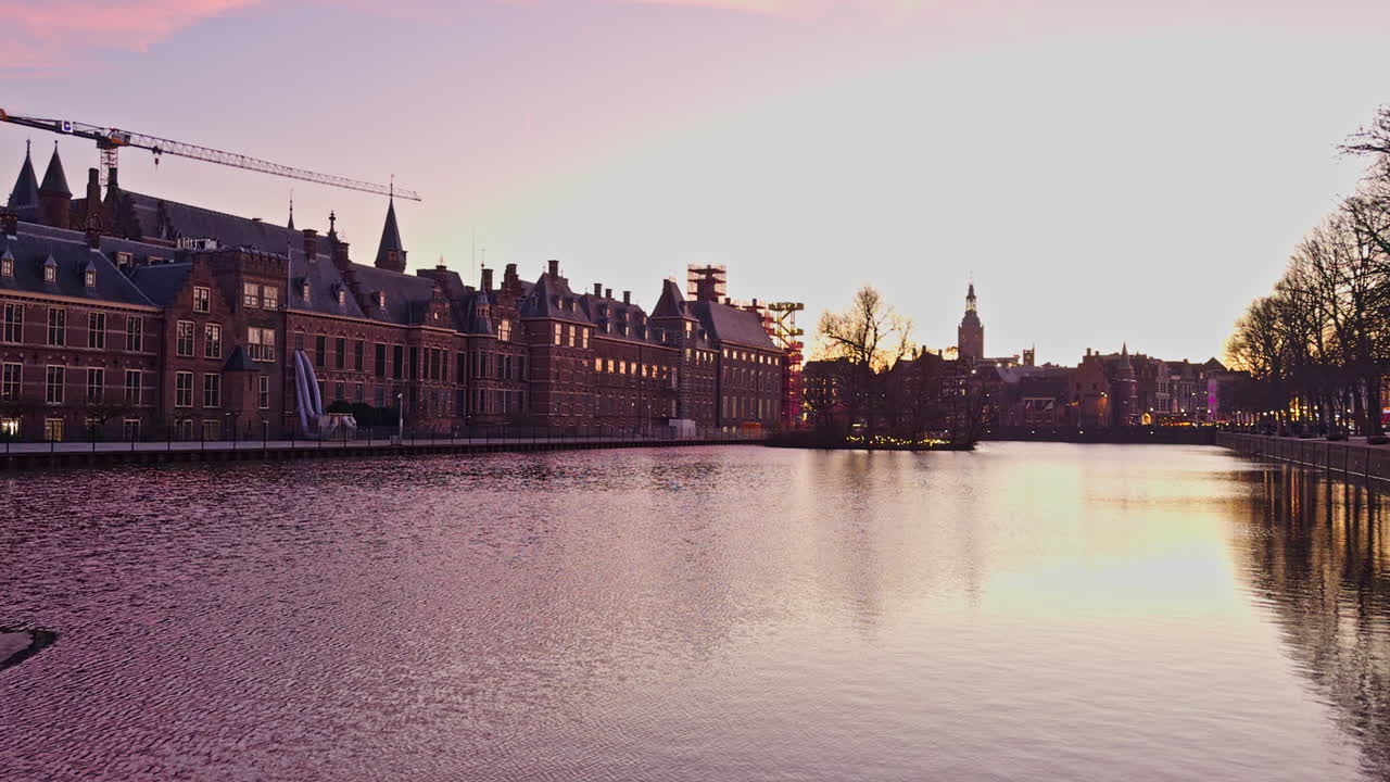 European modern city urban town center in the Netherlands in the Hague with buildings and water pond in golden hour early evening before sunset, wide low angle view
