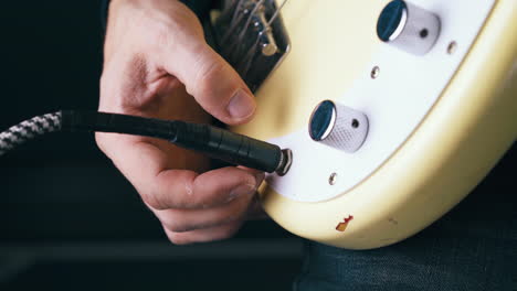 person connects quarter-inch amplifier jack to metal output