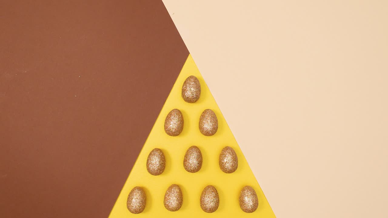 los huevos de glamour dorado de pascua se mueven en un fondo desnudo dorado de tres colores.