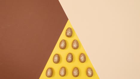 easter golden glamour eggs move on three colored golden nude background. stop motion flat lay pattern