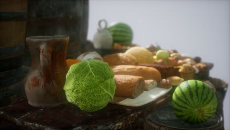 mesa de comida con barriles de vino y algunas frutas, verduras y pan