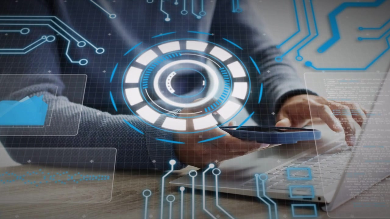 Man tapping phone and typing laptop keys at desk, activating HUD and tech overlays for data