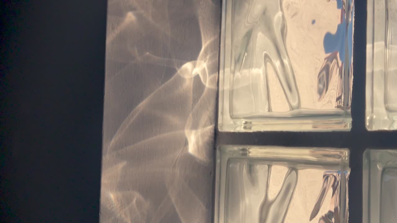 esta toma se enfoca en las formas creadas por la luz refractada a través de una ventana texturizada