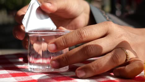 woman removing the cover from a plastic cup of water