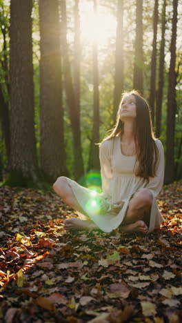 young woman sitting peacefully in a sunlit autumn forest