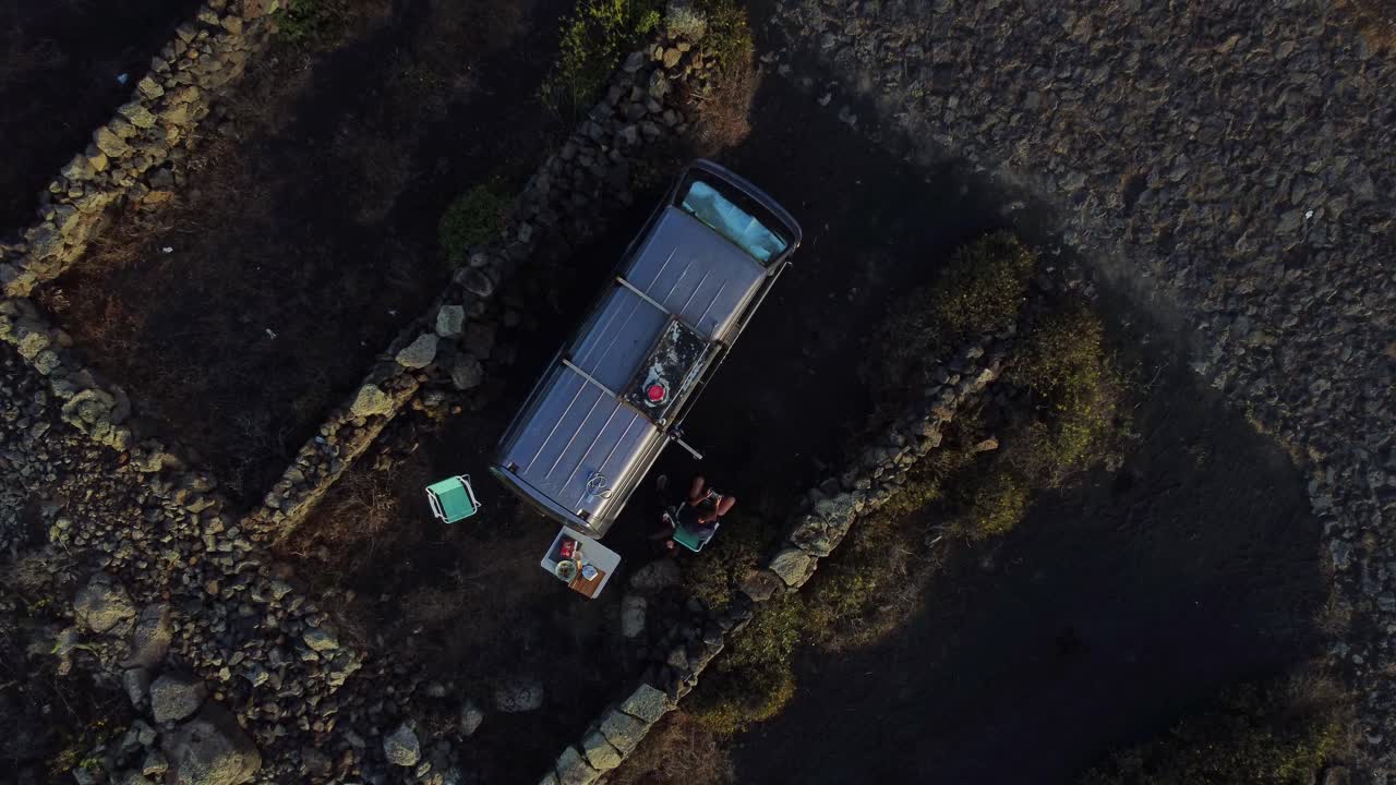 Topbillede af en campingvognspark i det klippefyldte landskab ved La Corona-vulkanen på Lanzarote, Spanien. Luftfoto