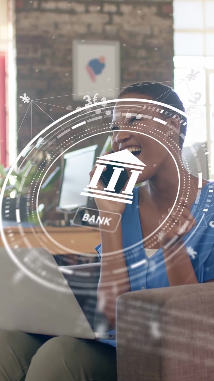 Vertical video: Woman on couch answering call, tapping laptop, overlaying BANK HUD for transfer