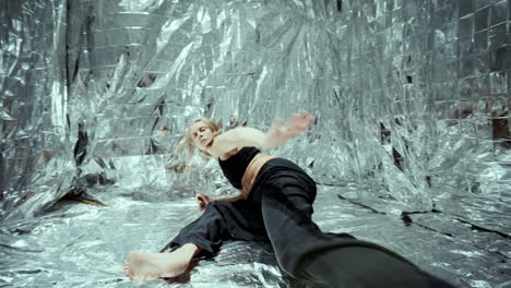 artistic dancer performing contemporary choreography on floor covered with foil