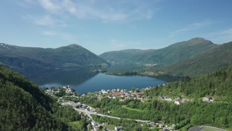 Tilt-up-from-Tveitane-Vaksdal-showing-overview-of-mountains,-sea,-osteroy-and-road-E16